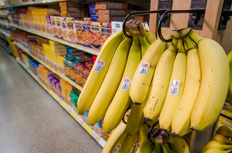 Yellow Bananas hanging in a grocery store aisle